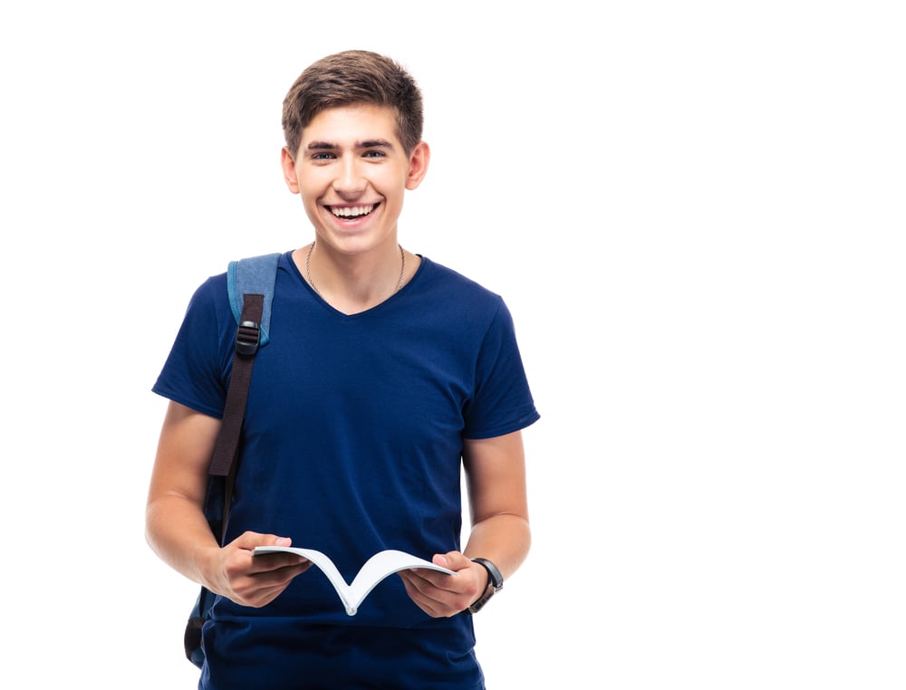 Happy male student standing and holding book isolated on a white background. Looking at camera-1